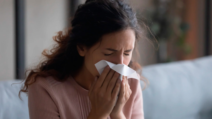 Pessoa assoando o nariz por alergia